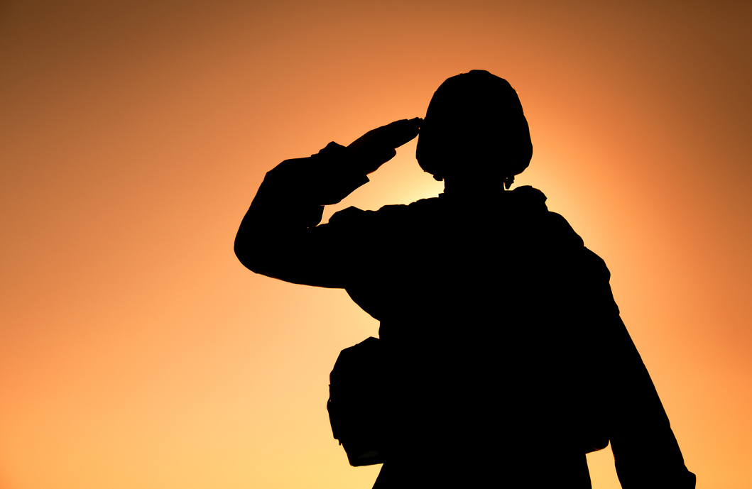 Silhouette of Soldier Salutes on Sunset 